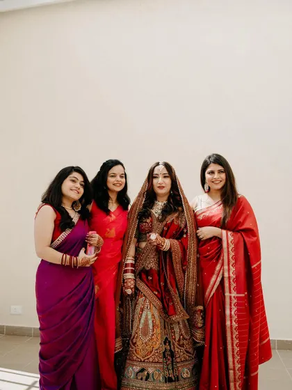 A beautiful portrait of the bride with her bridesmaids, all dressed in vibrant sarees, celebrating their friendship.