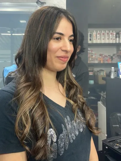 A beautiful shot of a client's new hairstyle, featuring soft, natural-looking waves and highlights that catch the light perfectly.