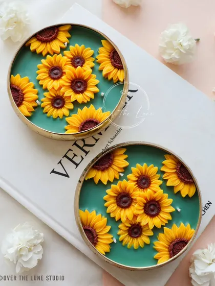 Two of my brand new Sunflower Urli candles, ready to bring warmth and cheer to any room. The contrast between the bright yellow sunflowers and the deep green wax is one of my favorite combinations.