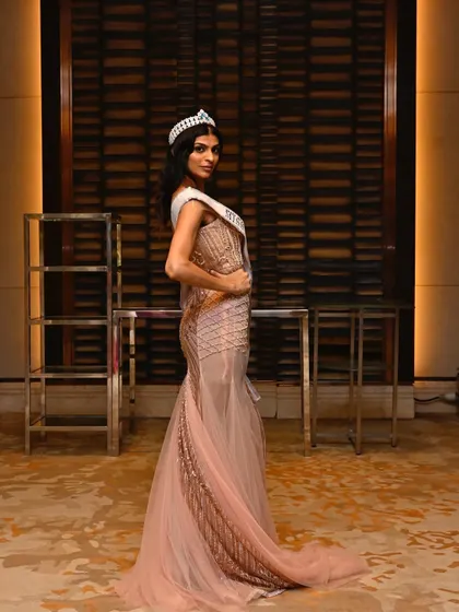 A side profile showcasing the sleek hairstyle and the contouring that defines her features for the camera. Every detail is considered for a perfect stage presence.
