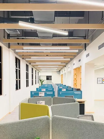 The open-plan workspace at the DLF hospitality office. We used hexagonal pods and low partitions to create versatile workstations that encourage collaboration while maintaining a sense of personal space, enhanced by ample natural light.