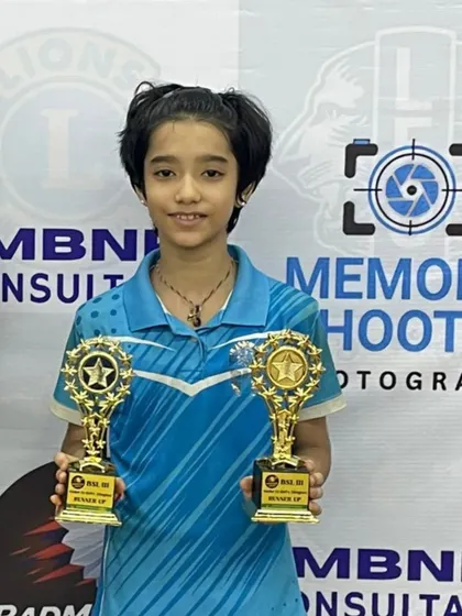 A double victory for one of our young stars. Holding two trophies shows her versatility and success in multiple categories during the tournament.