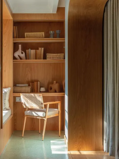 A cozy study nook within the kids' suite at Summer Haus, featured in Elle Decor. The curved wooden archway and built-in shelving create a perfect little hideaway.