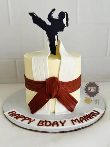 A unique cake designed to look like a karate uniform (gi) with a brown belt, celebrating a martial artist's birthday.