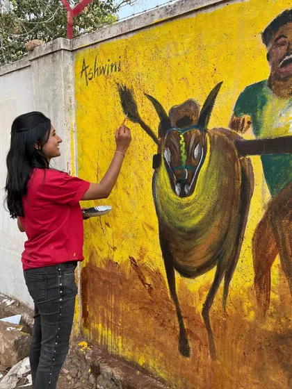 The process of painting a large mural involves focus and patience. Here, I'm carefully adding highlights to one of the bulls, using a fine brush to bring out the details and energy of the animal.
