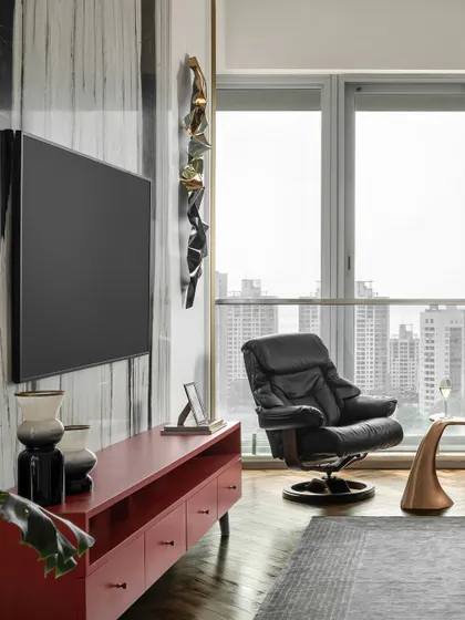 A view of the master bedroom, showing the comfortable lounge chair by the window. It's the perfect spot to enjoy the city views, blending the outdoors with the serene interior.