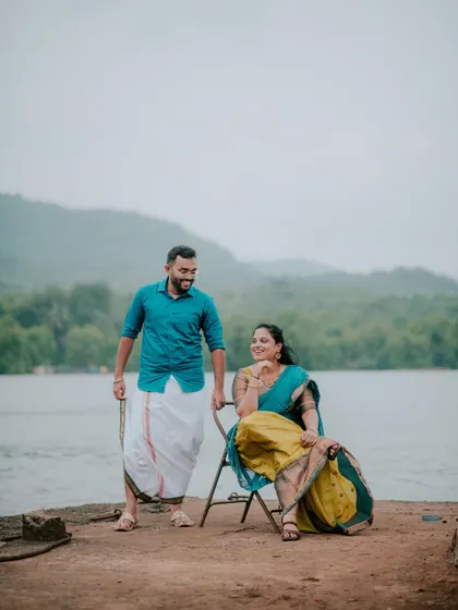 A relaxed and happy portrait of a couple by the water during their pre-wedding session.