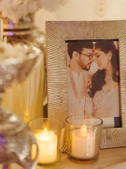 Personal touches are key. A framed photo of the couple is placed amidst candles and silver decor items, making the welcome night feel intimate and personal.