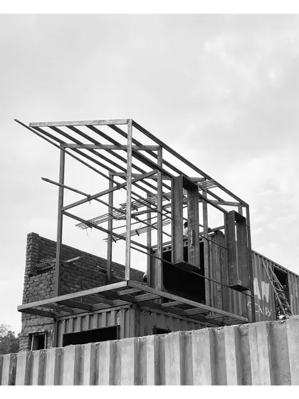 The addition of a metal frame for a sloping roof and an extended upper level. This shows how I augment the basic container form to create more complex architectural shapes.