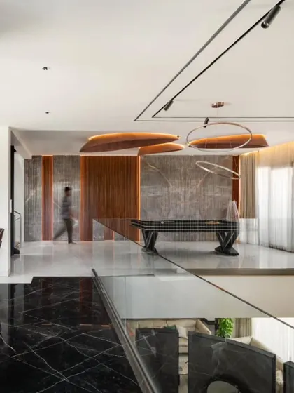 An upper-level lounge in the Timber Edge project, featuring a snooker table and views down to the lower level, showcasing the home's vertical connectivity.
