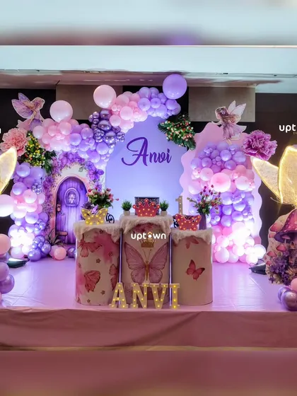 The full setup for the fairy theme, showing the purple balloon arch and custom props.