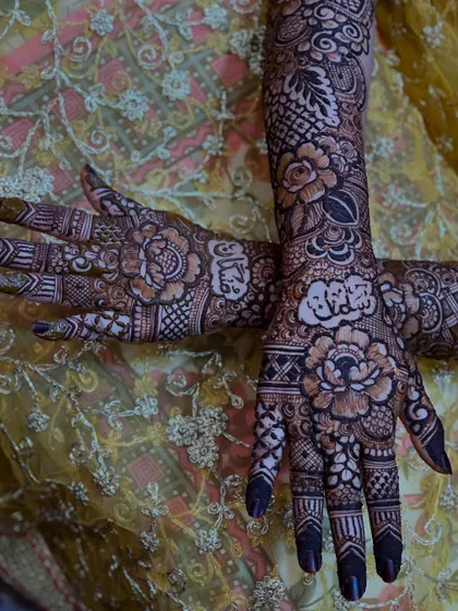 A close-up of the palms, where the floral design is most intricate and features personalized elements for the bride.