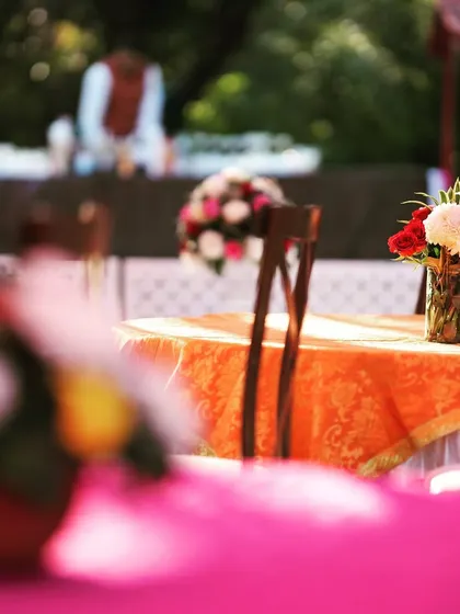 An atmospheric shot of a daytime event, with colorful table settings and floral arrangements creating a beautiful, soft-focus background.