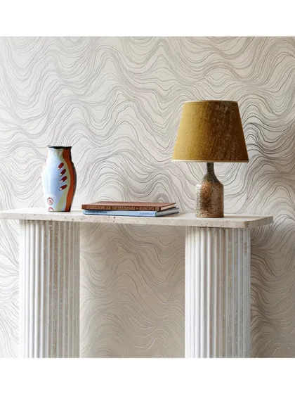 The 'Bayuda' wall covering features a delicate, wave-like pattern that adds gentle movement and texture. It's a sophisticated choice for an entryway or accent wall, creating a calm and elegant first impression.