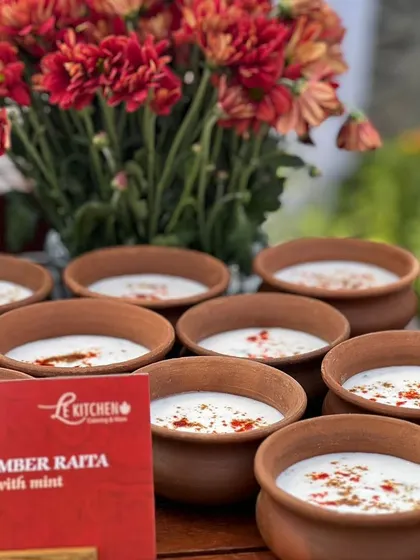 Cool and refreshing Cucumber Raita served in individual terracotta bowls, a perfect accompaniment to our spicy Indian main courses.