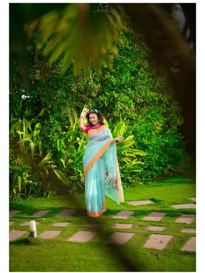 A playful and happy outdoor portrait. The way she holds her sunglasses and smiles gives this saree shot a fun and modern feel.