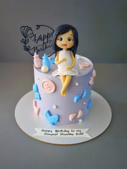 A birthday cake for an expecting mom. This cake celebrates both the mother's birthday and the baby on the way, with a beautiful figurine and baby-themed decorations.