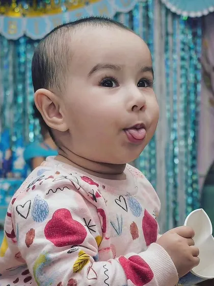 Innocence is a kind of insanity. This candid shot of a toddler sticking his tongue out at a party is a perfect example of capturing a child's fun and quirky personality.