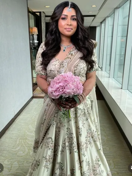 Soft, voluminous waves for a bride holding a bouquet, a timeless and romantic wedding day style.