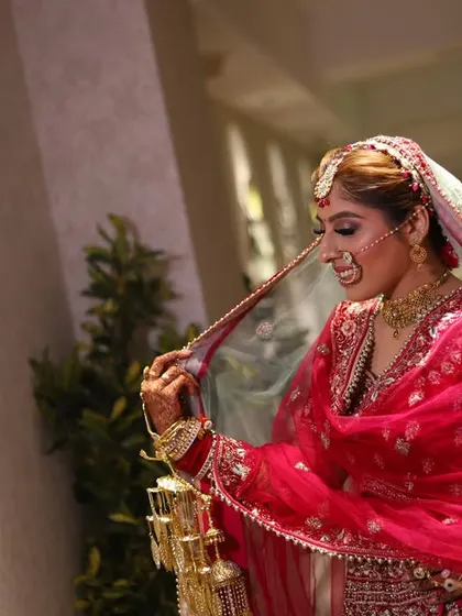 A candid moment of the bride adjusting her veil, full of grace and movement.