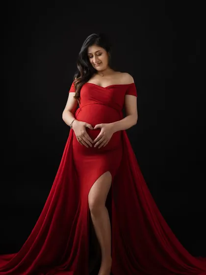 Making a heart shape with her hands on the baby bump. It's a simple, sweet gesture that says "I love you already."