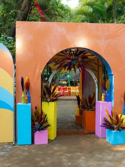 The entrance to the carnival-themed party was designed to be bold and welcoming, with a colorful arched gateway and vibrant floral arrangements.