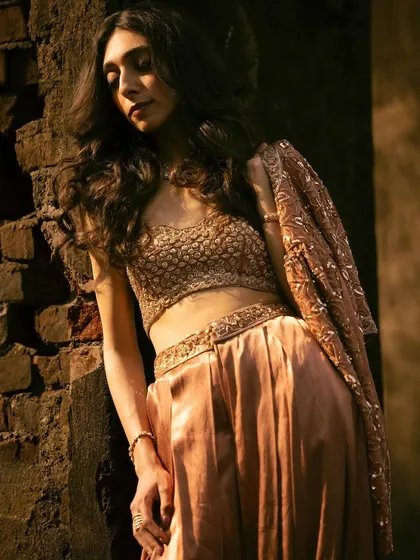 A close-up shot against the brick wall, highlighting the texture of the outfit and the mood of the shoot.