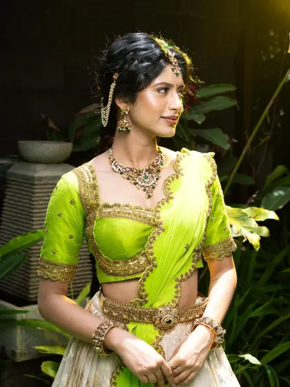 This 92.5 silver jewellery set with an antique gold finish is perfect for a mehendi or sangeet. The green and red stones add a pop of color to the lime green and white lehenga.