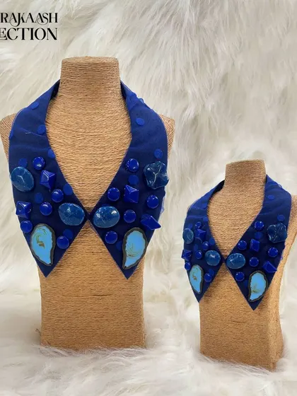 A bold, geometric statement collar in a deep royal blue. This piece is embellished with a variety of polished blue and turquoise-colored stones in different shapes and sizes.