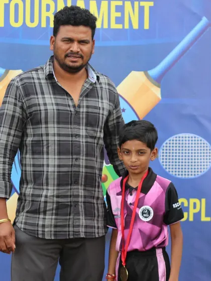 An official poses with a young medalist at the RSCA Dasara Cup.