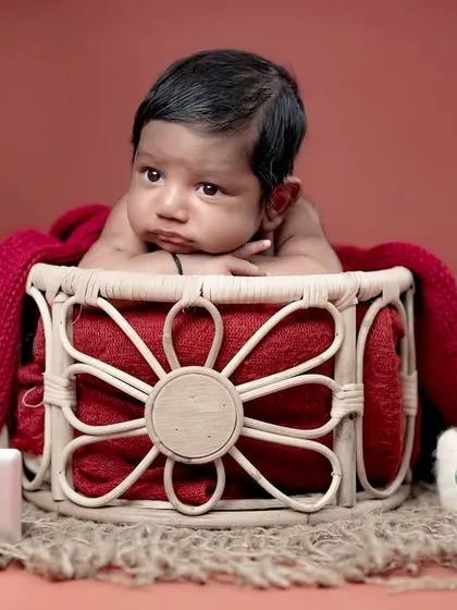 A thoughtful newborn in a basket, with a tiny laptop and coffee mug. A fun and modern take on a newborn shoot for tech-savvy parents!