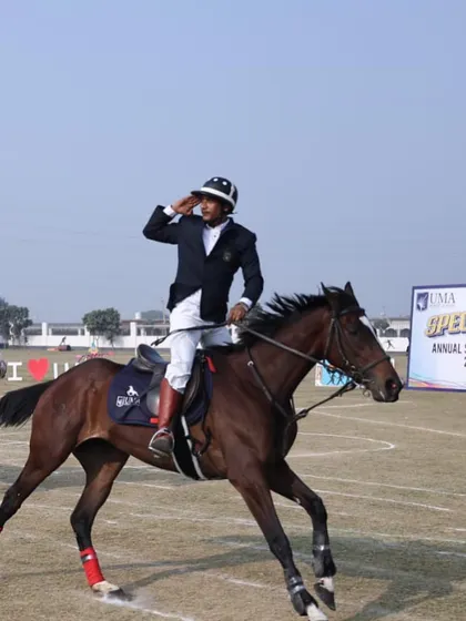 An equestrian saluting while riding during what appears to be a sports day event. We instill discipline and sportsmanship in all our riders, preparing them for competitions.