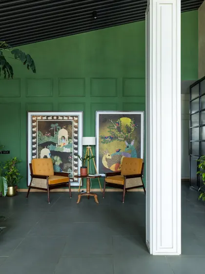 Another view of the Primus lounge, highlighting our custom designed armchairs with cane weaving against a rich green wall. The design blends natural materials and soothing colors to foster a sense of well being.