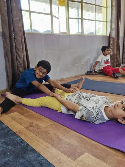 Little yogis learning to support each other. This partner stretch helps develop flexibility and trust, all while sharing a playful moment.