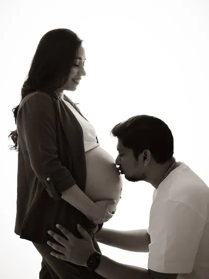 A timeless black and white portrait of a dad-to-be kissing the baby bump. This silhouette shot is full of emotion and love.