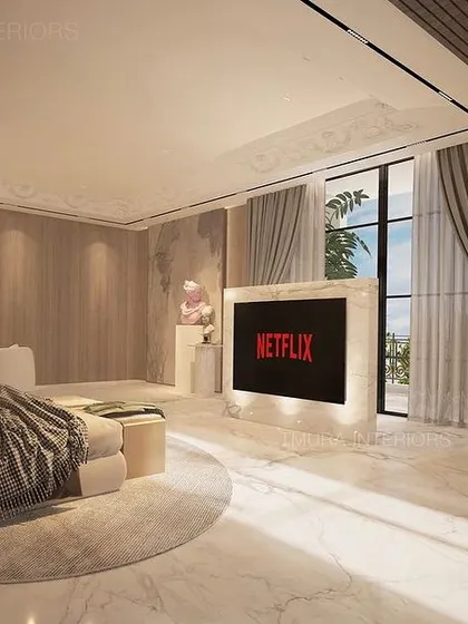 This perspective shows the full breadth of the bedroom, from the plush bed and seating area to the dedicated study corner with a fluted wood panel backdrop. The organic-shaped pendant lights soften the room's modern lines.