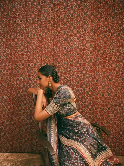 A side profile against a patterned Ajrakh backdrop. This shot emphasizes the synergy between the garment and the environment, a key element of my art direction.
