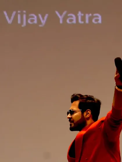 Raising the mic in a gesture of victory and celebration during 'The Vijay Yatra' event. My body language is a huge part of how I communicate energy.