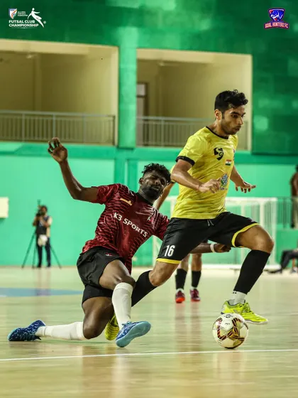 A player trying to dribble past a defender on the ground.