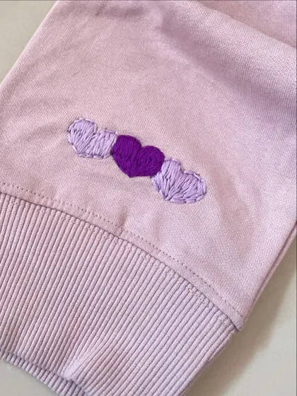 Little details matter. These three embroidered hearts on the cuff of a sweatshirt add a small but sweet touch of color and love.
