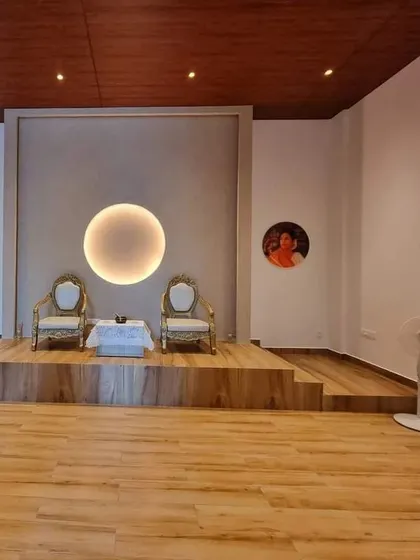 The stage of our meditation hall, with two chairs set for a satsang. The circular light fixture symbolizes wholeness, unity, and the divine.