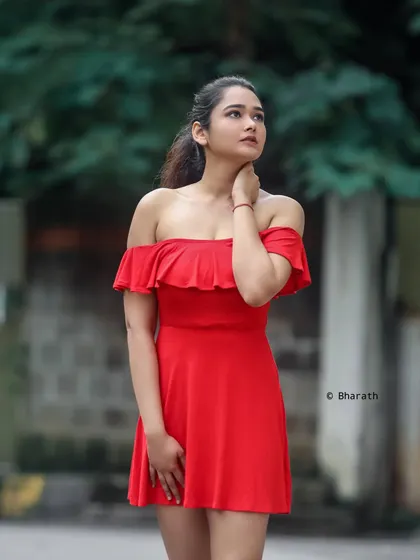 A beautiful outdoor portrait in a simple red dress. The soft, natural light and blurred green background make the subject stand out.