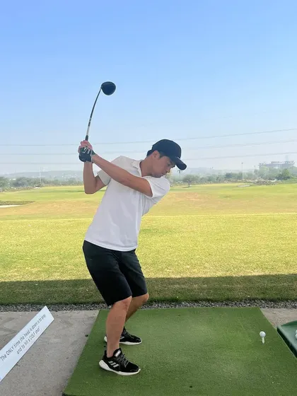 A player follows through on his swing, enjoying a perfect weekend day for golf.