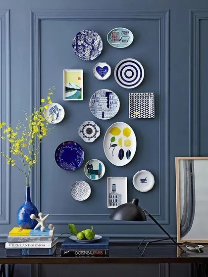 A gallery wall of decorative plates can be a unique form of personal expression. We arranged this collection of blue and white plates of various shapes and patterns against a bold blue wall to create a striking focal point.