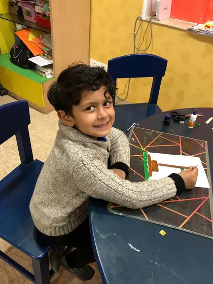 A happy smile from a child working on his Republic Day craft. We celebrate national holidays with art and stories about our country.