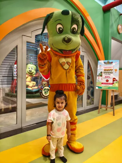 A little guest poses confidently with our mascot, Tinga Dojo. We love to see kids feeling happy and brave in our play environment.