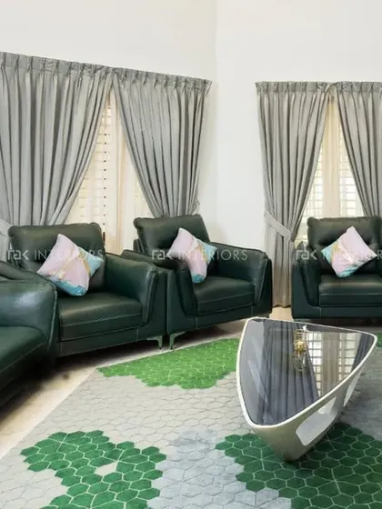 A living room with dark green leather sofas and a unique wall covered in a textured, multi-colored 3D pattern.