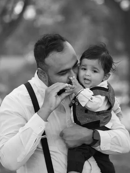 A tender moment between father and son. This candid black and white shot captures a gentle interaction that speaks volumes about their relationship.