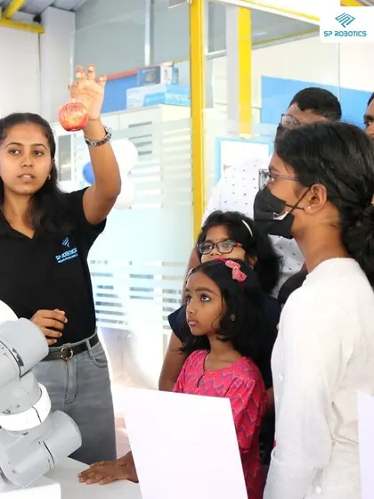 An instructor from our team demonstrates the capabilities of a robotic arm to an engaged audience at our Maker Lab. Our workshops are interactive, encouraging questions and direct participation.