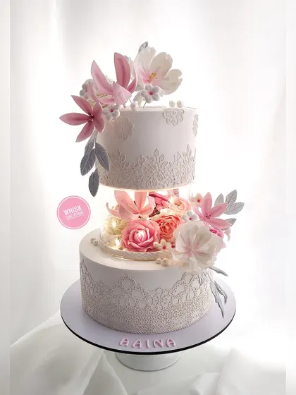 A showstopper cake that will have your guests talking. This floating tier design is adorned with edible lace and handcrafted sugar flowers, with lights in the middle for a magical effect.